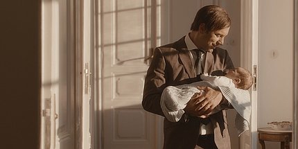 Vater hält Baby liebevoll im Arm