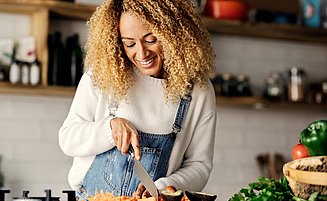 Frau kocht Hühnersuppe bei einer Erkältung.