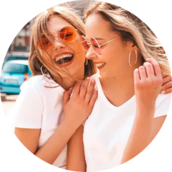 Junge lachende Frauen mit Sonnenbrille und weißen T-Shirts